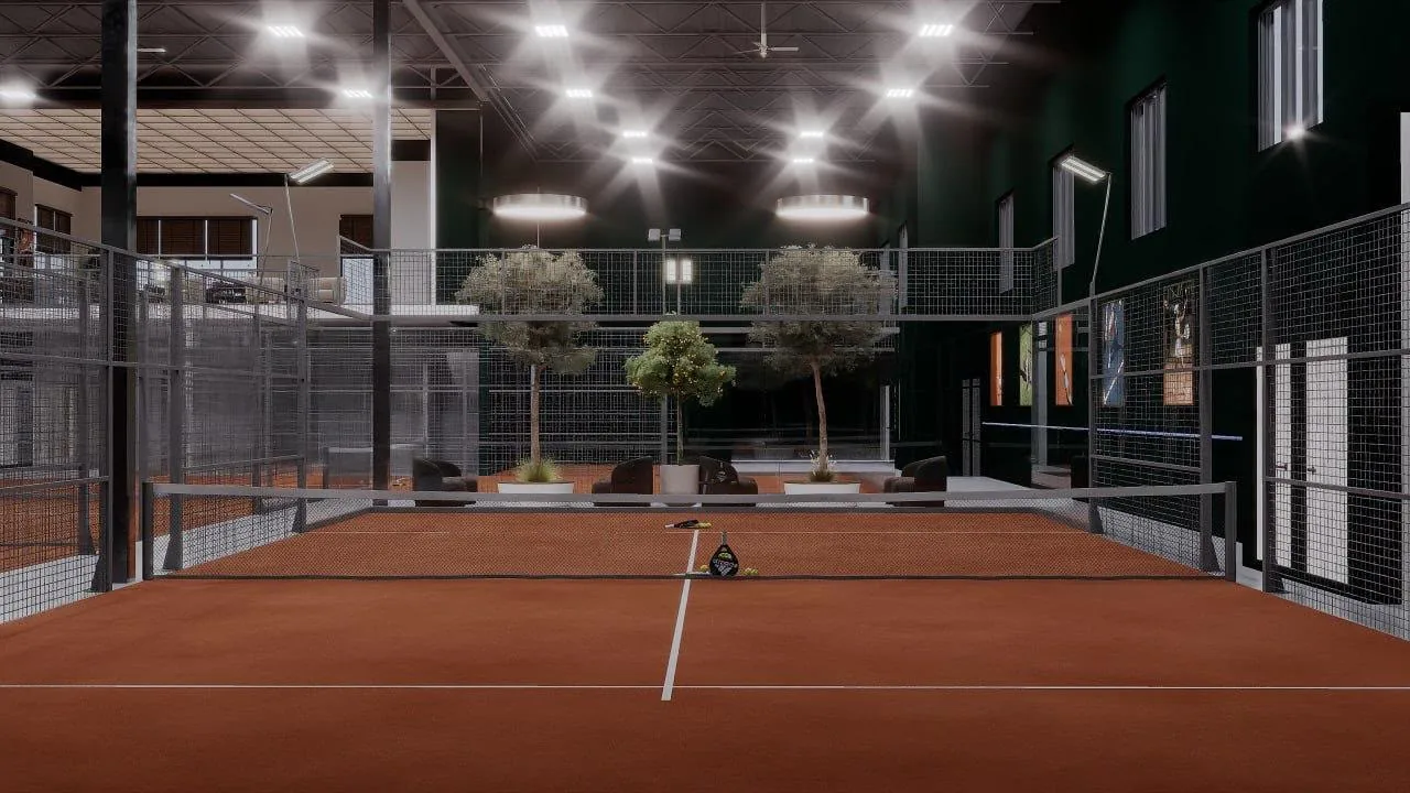 A full panoramic indoor padel court with a clay surface and courtside lounge seating at Padel Model